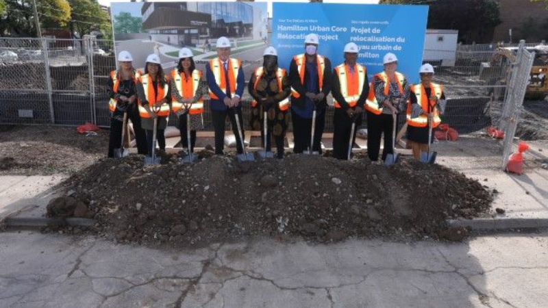 People in hard hats and safety vests with shovels at a ground breaking event