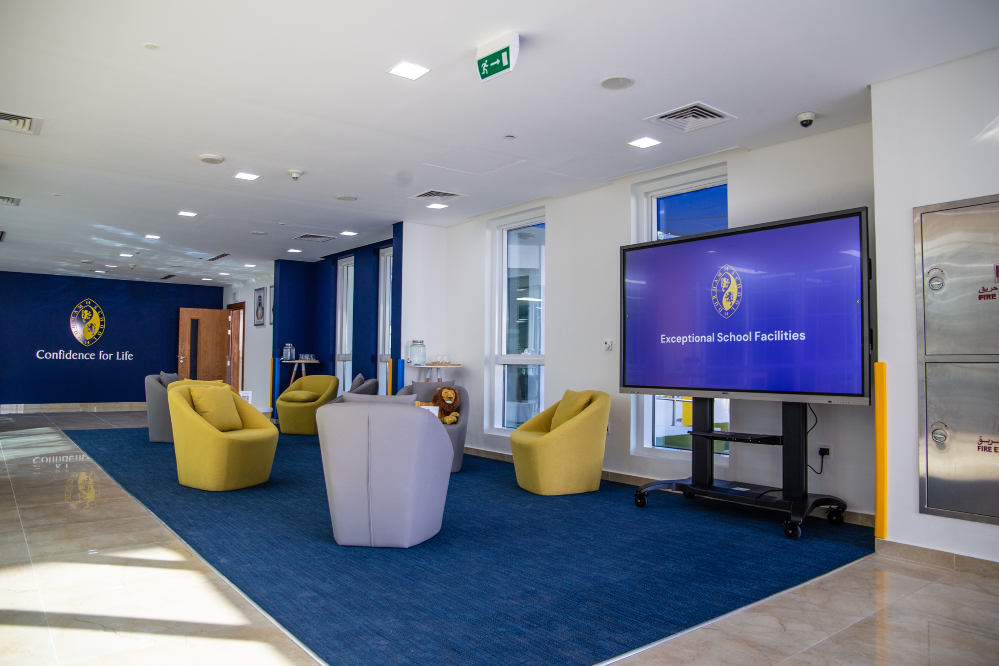 image of school lobby with television screens and chairs