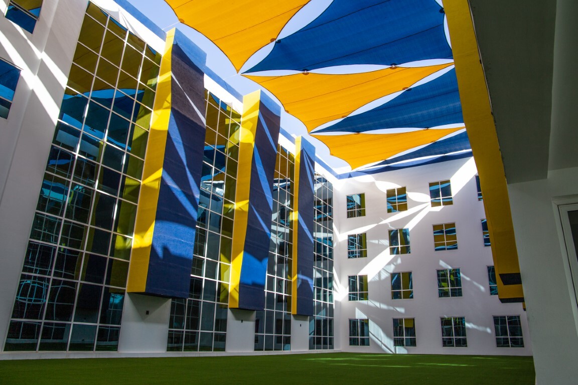 white building with black windows and blue and yellow banners